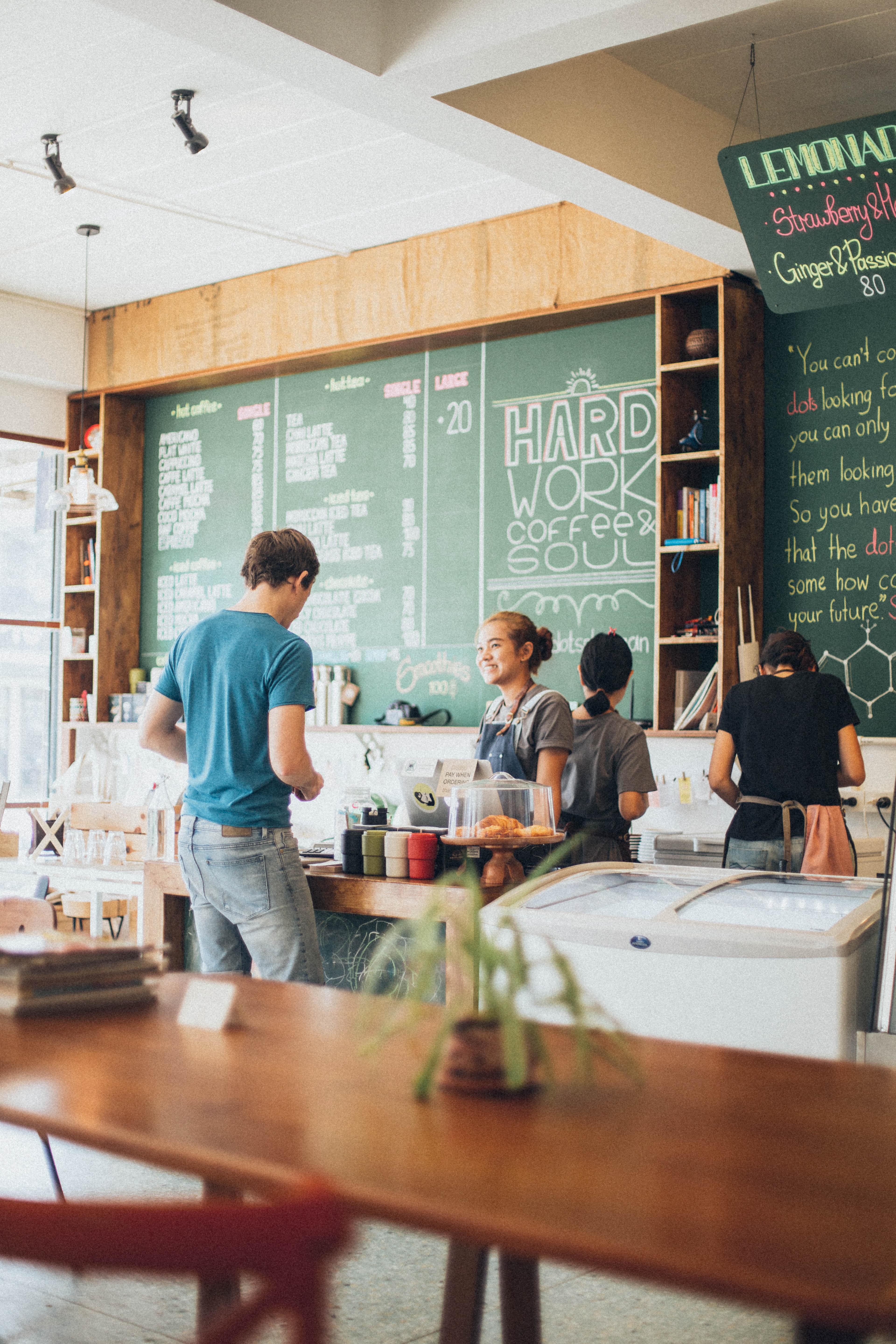 A man and a barista standing in a cafe A man and a barista standing in a cafe
