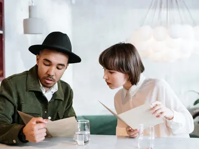 A man and woman looking at a restaurant’s menu