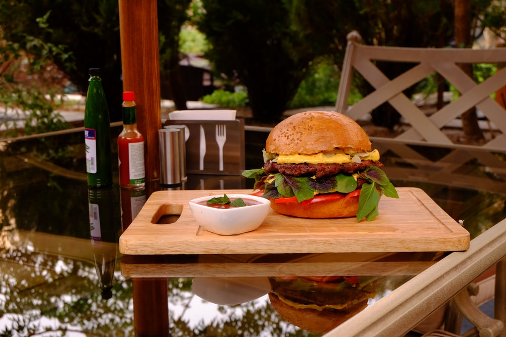 A giant burger on a cutting board