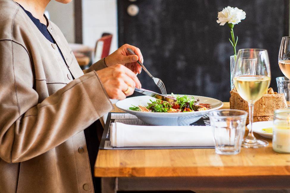 A person cutting up their salad