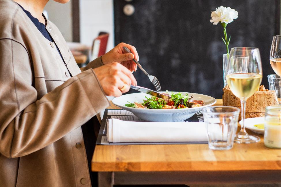 A person cutting up their salad